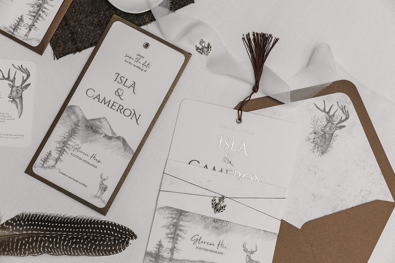 Silver-foiled Highland Romance Charmed Invite™ with silver thistle charm, and lined 'Highland Bronze Shimmer' envelopes