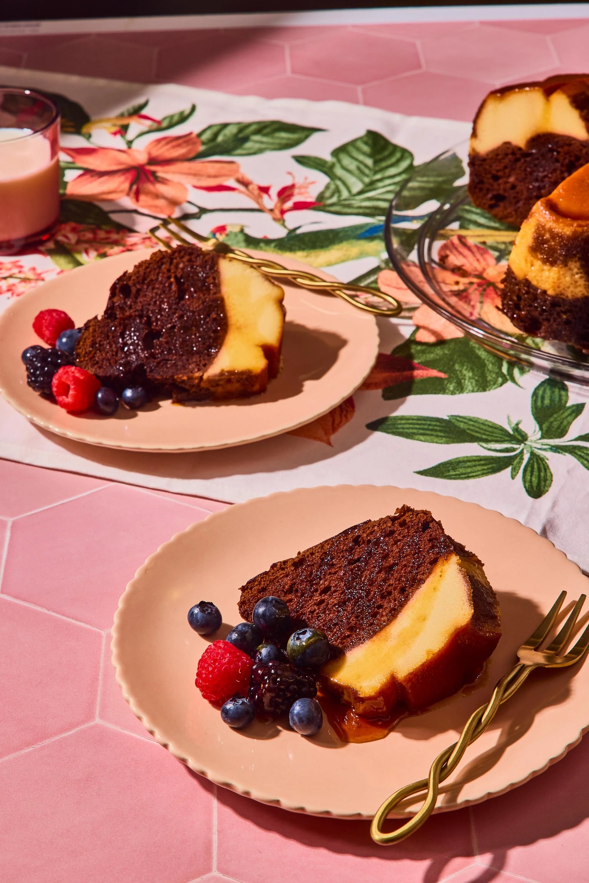 Slice of cheesecake with blueberries, raspberries, and blackberries on a pink plate