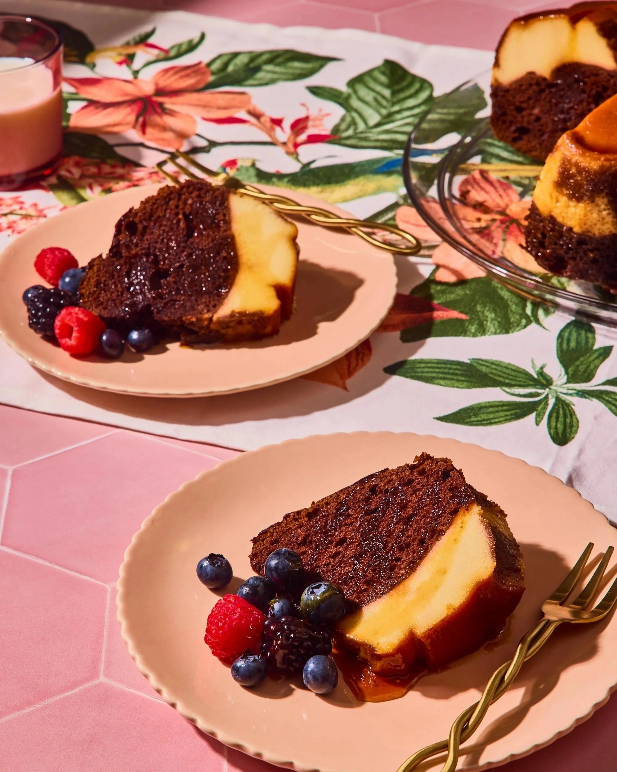 Slice of cheesecake with blueberries, raspberries, and blackberries on a pink plate