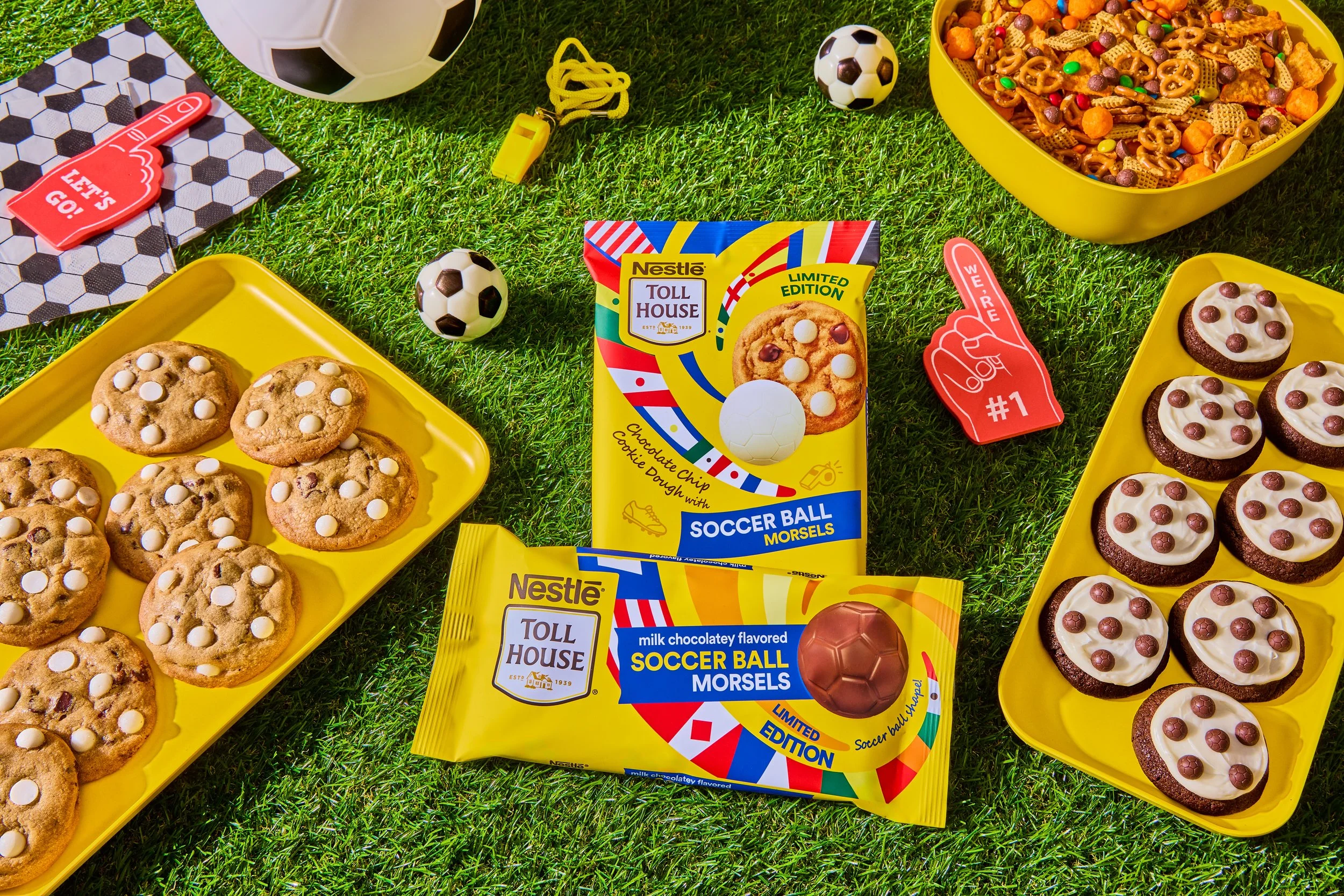 Cookies, chocolate, and snack foods on a grassy surface, with soccer-themed items and two packages labeled 'Soccer Ball Morsels'.