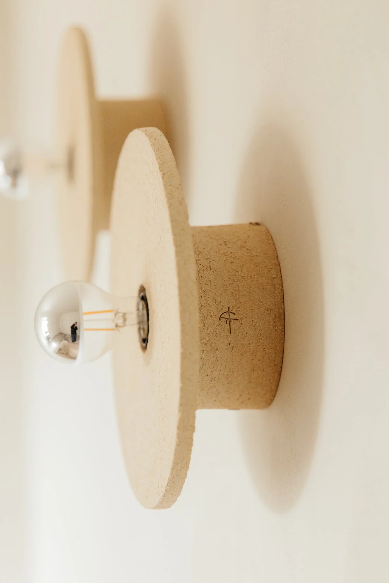 Keramische wandlichten aan de muur wit gekleurd met de lamp zichtbaar. 