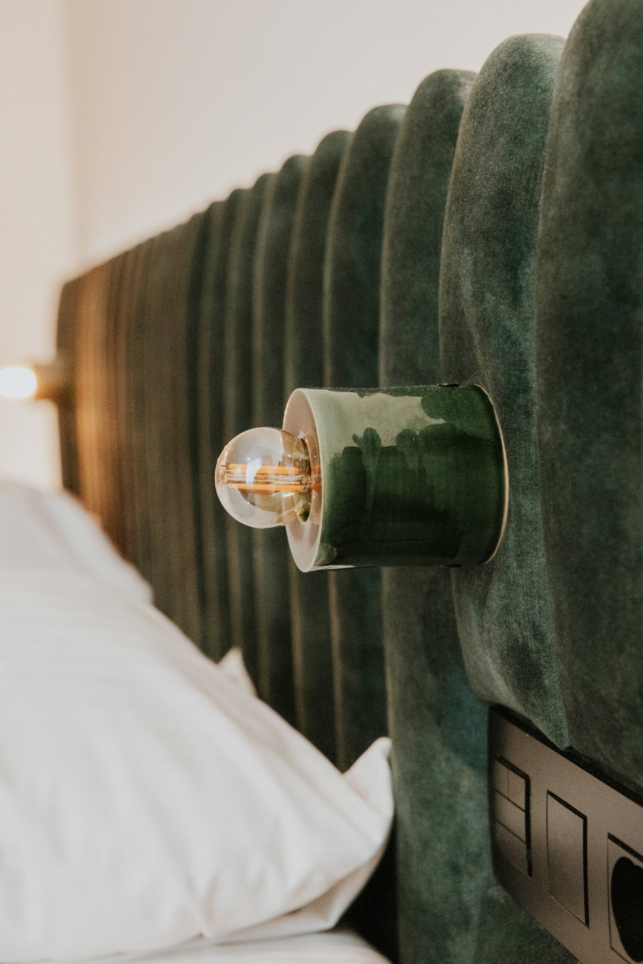 Bedlichtjes op de wand in een hotelkamer met schakelaar er onder.