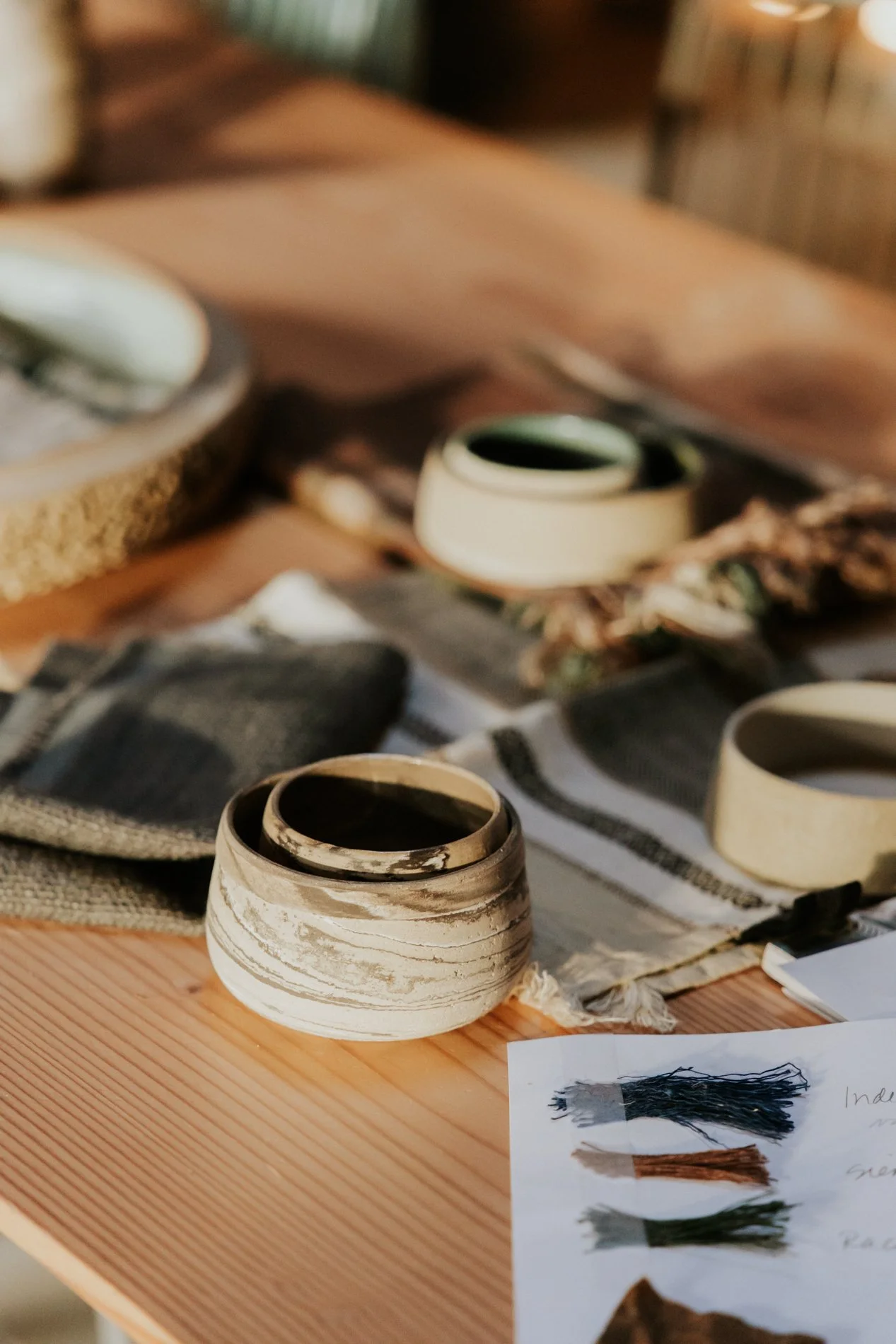 Staaltjes van stof en keramiek potjes op een houten tafel. Atelier Pyotr Morf.