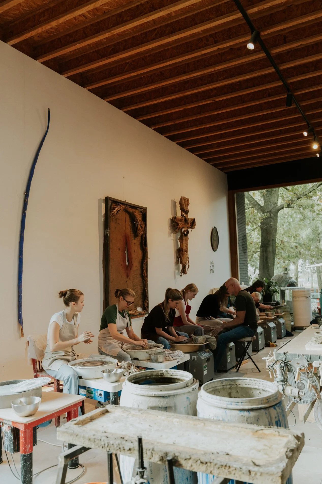 Cursisten die keramiek les volgen tijdens een teambuilding in een atelier van een pottenbakker