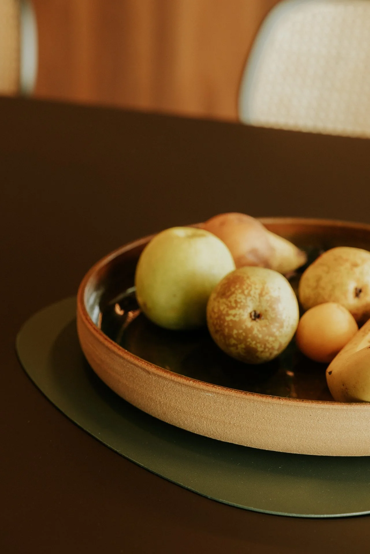 Fruitschaal met appels en peren op een zwarte tafel
