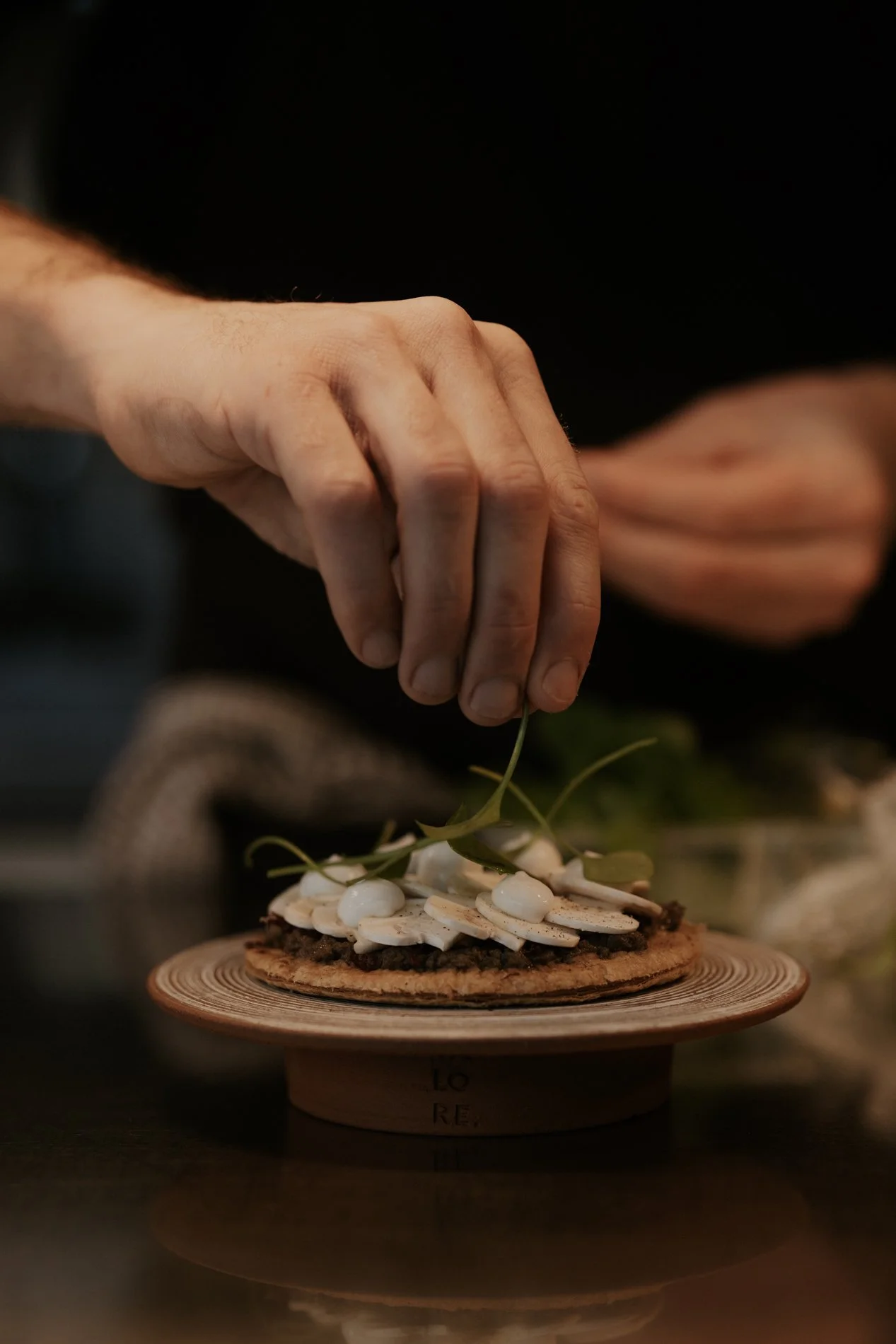 Chef die borden dresseert, bord op een tafel. Atelier Pyotr Morf