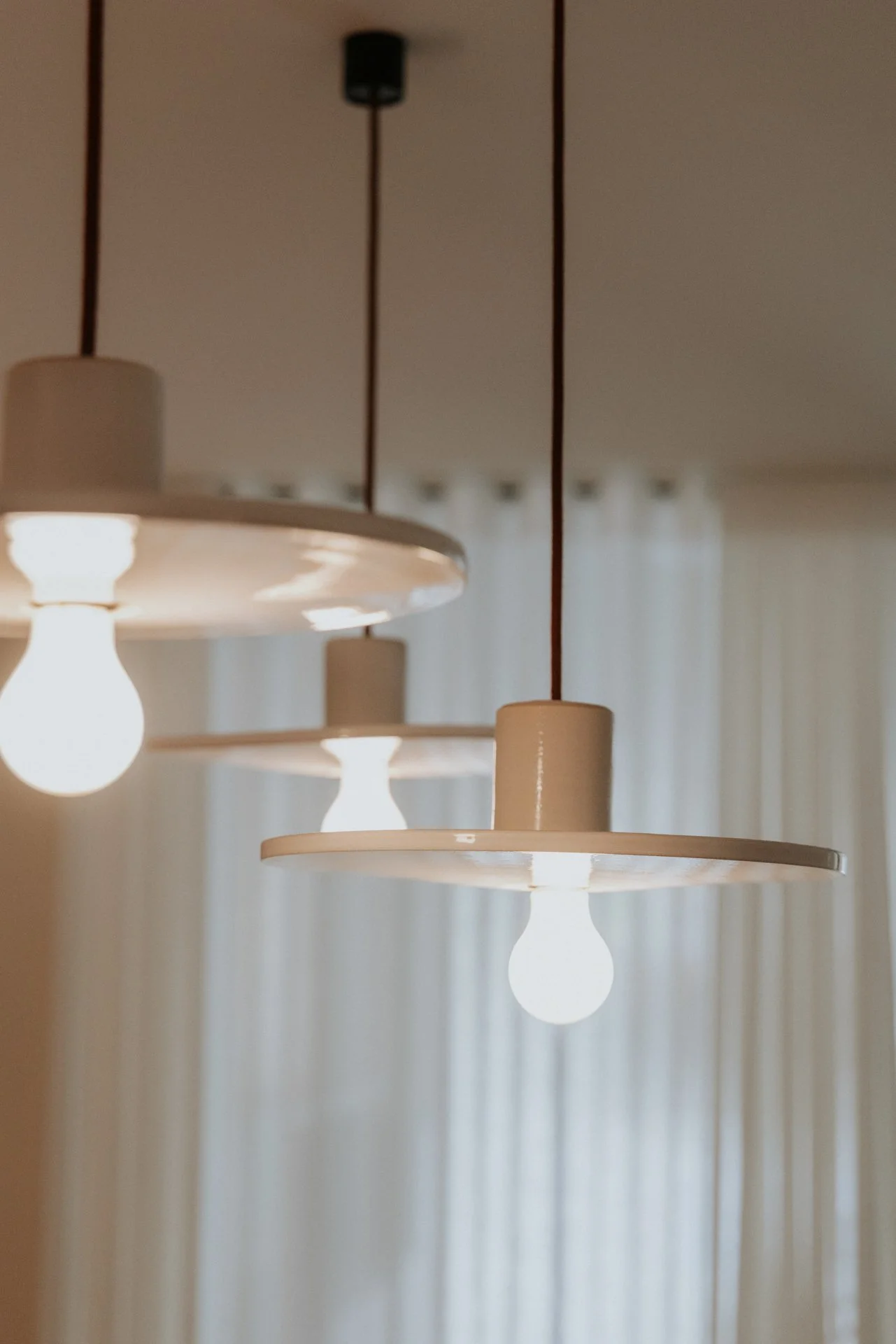 Detail hanglampen in een kantoor van een bank, kleur wit, op de achtergrond witte gordijnen.