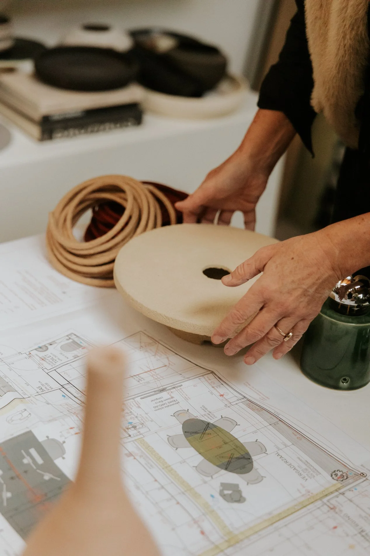 Interieurplan op de achtergrond, lamp vast in enkele vrouwen handen, materiaal touw op de achtergrond.