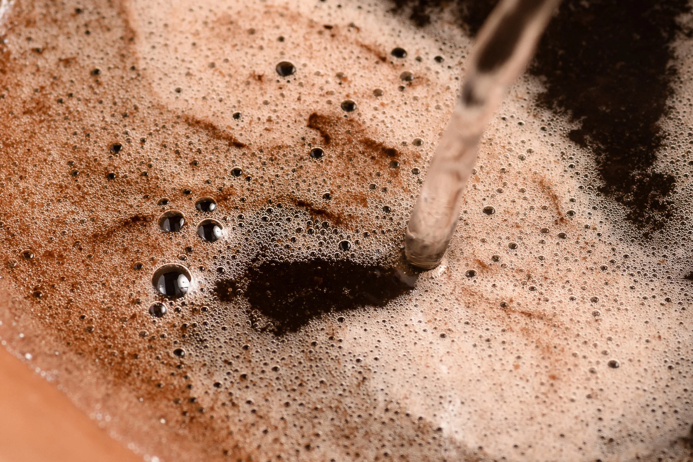Closeup shot of hot water being poured over coffee grounds in a Chemex.