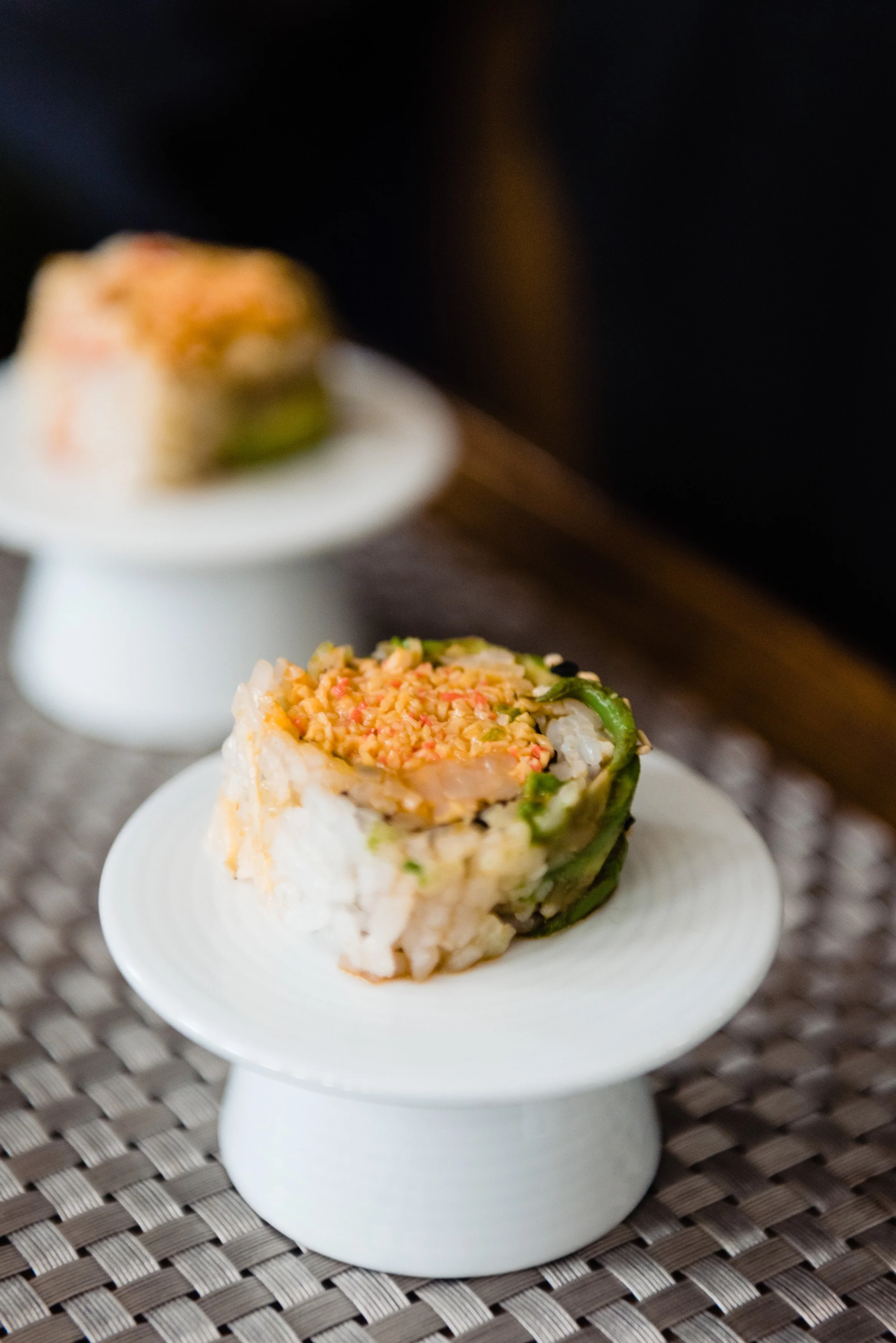 Individual sushi roll bites on little plates.