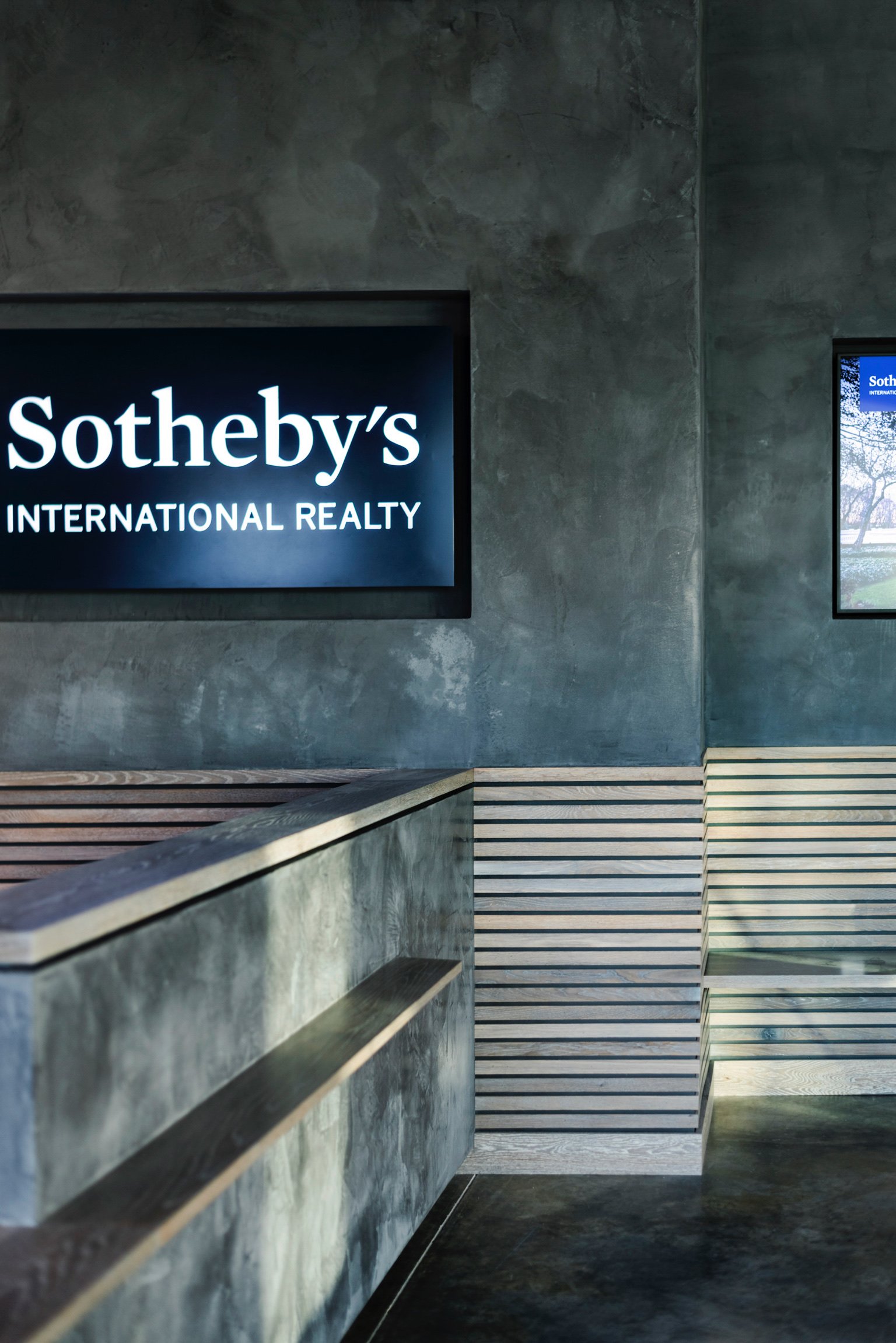 Summit Sothebys draper reception desk textured wood and plaster reception