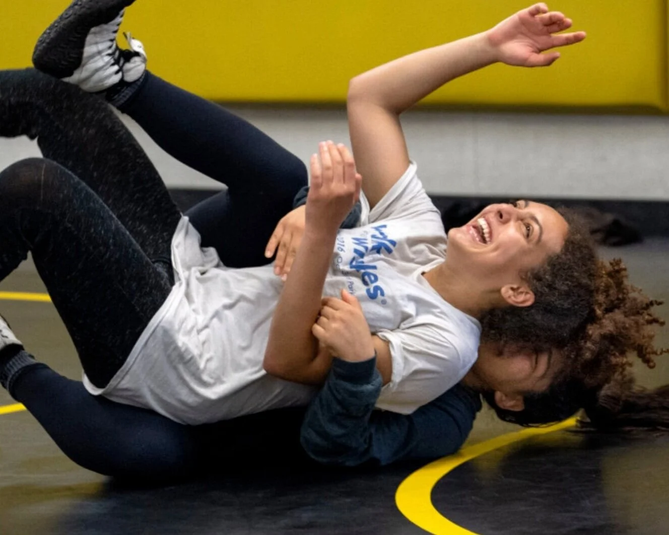 Children practising wrestling on a mat
