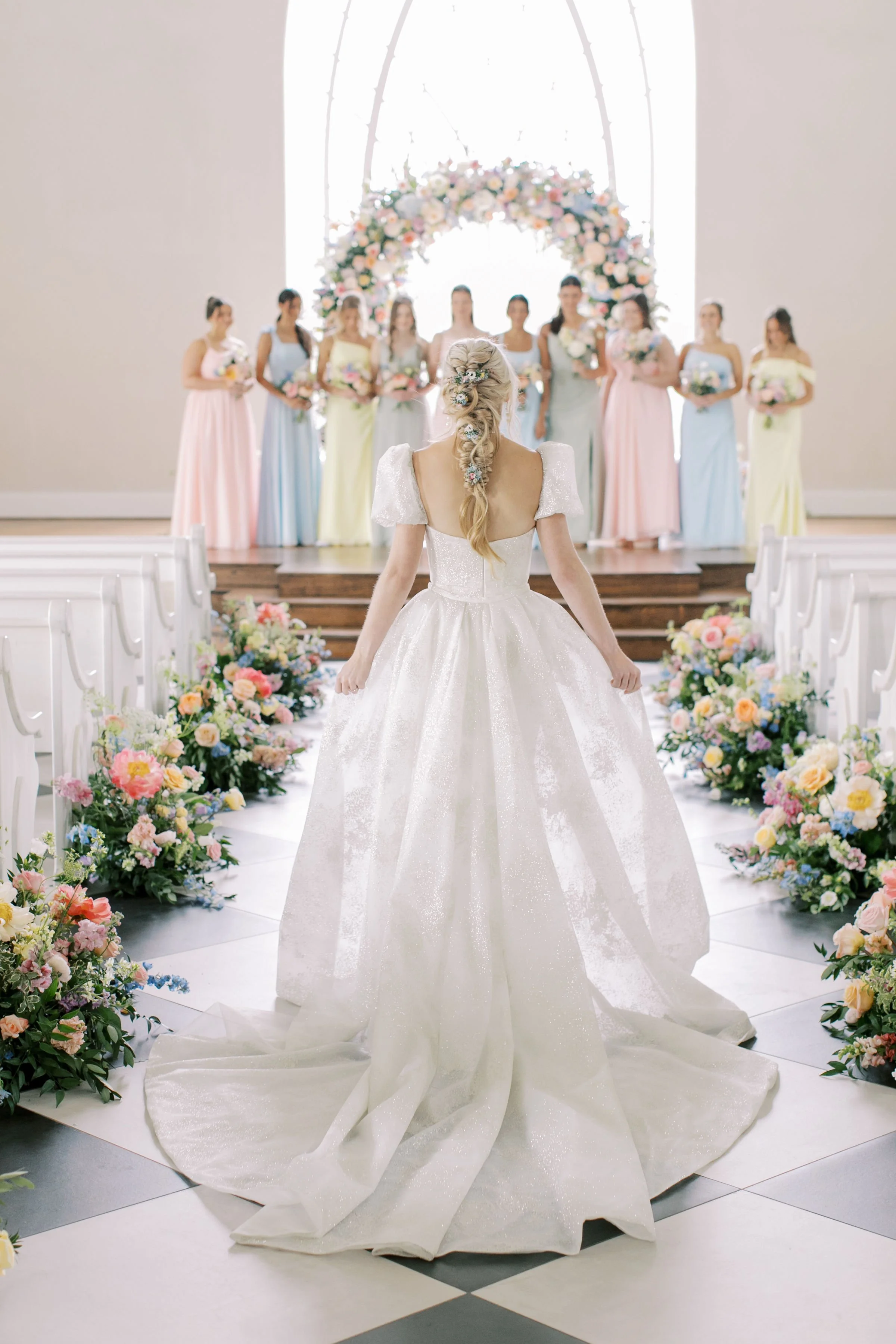 Bride walking towards her bridal party with amazing florals designed by wedding florist Houston