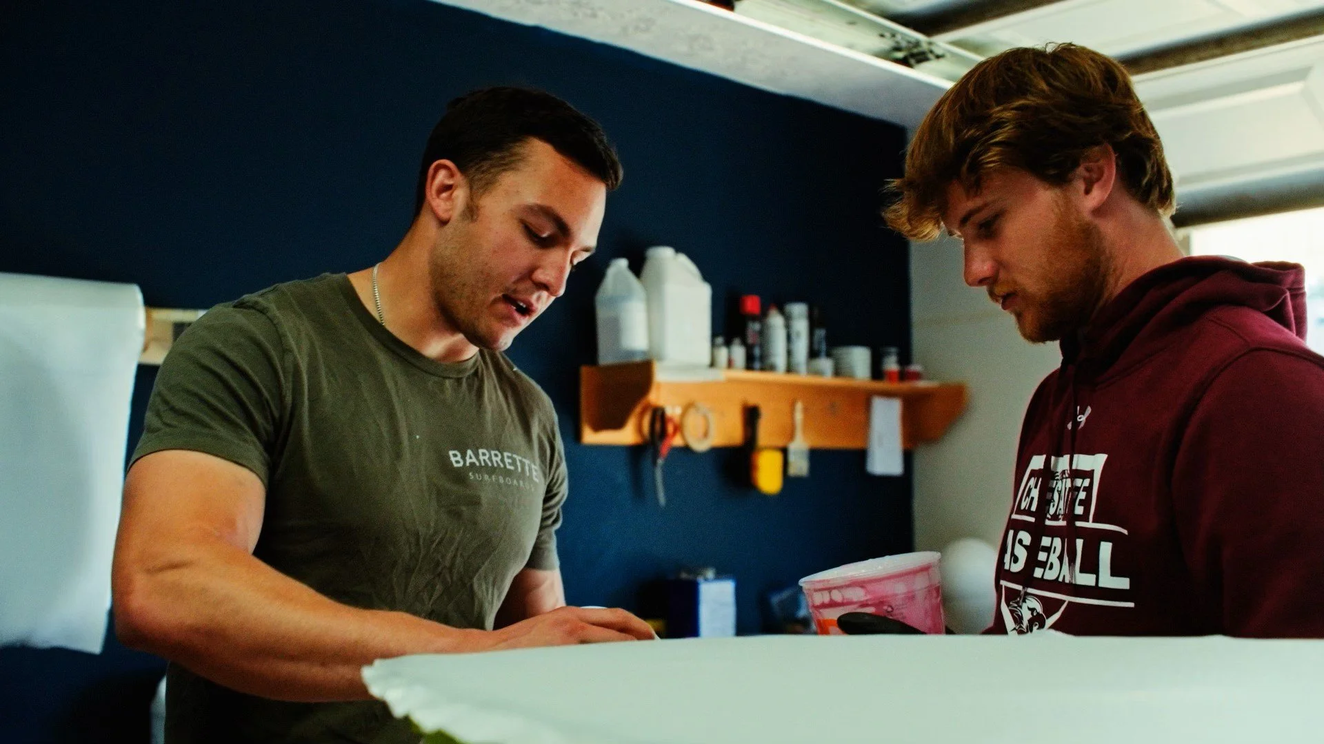 Austin Barrett works with surfer to shape a custom board