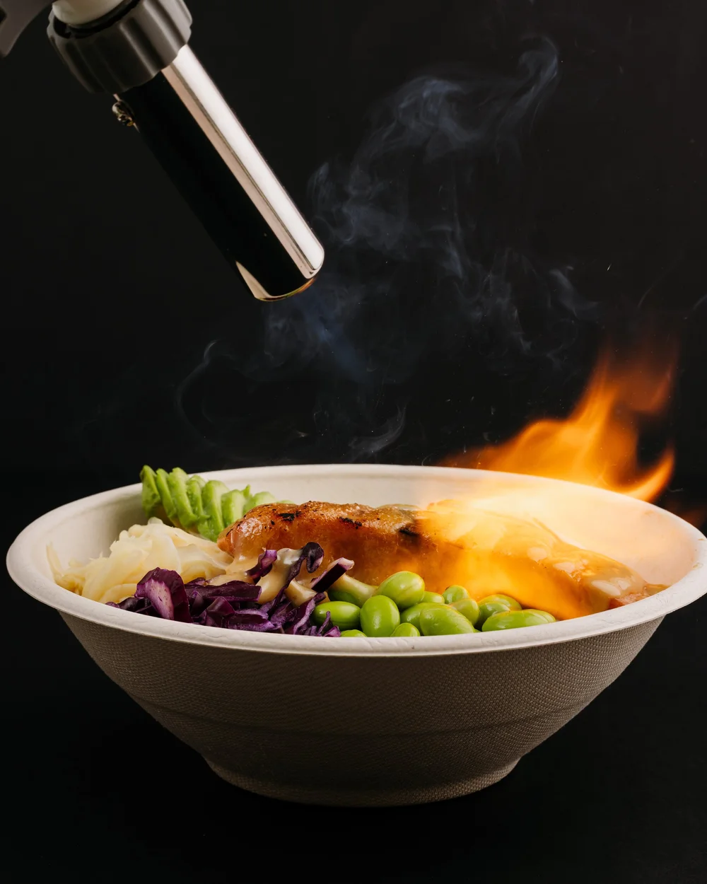 A Pokerrito warm bowl being finished with a torch flame