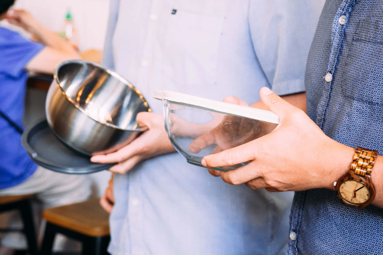 Guest handing a reusable bowl to a Pokerrito team member