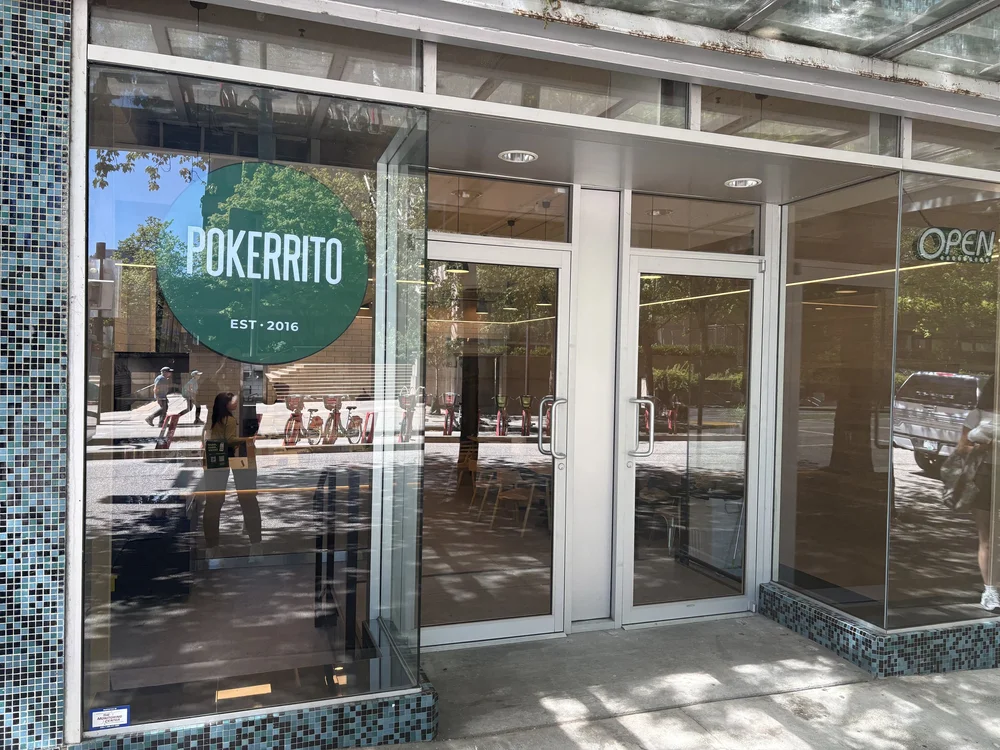 Glass storefront of Pokerrito Hornby on Hornby Street with the round Pokerrito window sign
