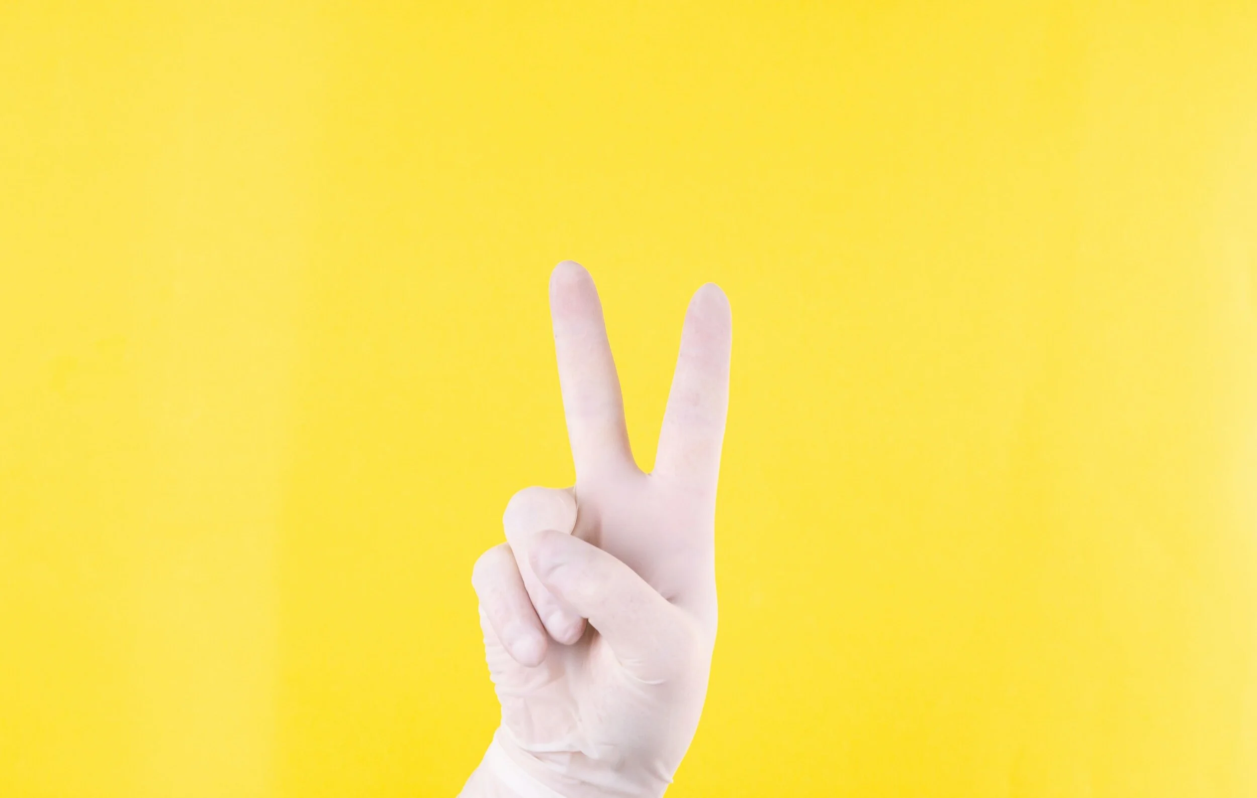 hand making number two against yellow background