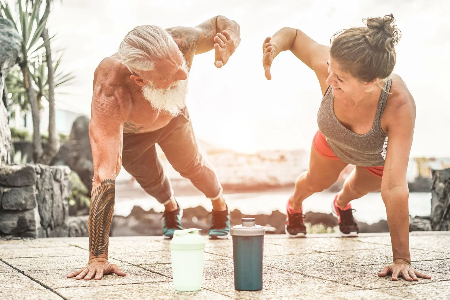 Fit couple over 50 doing planks and high diving each other
