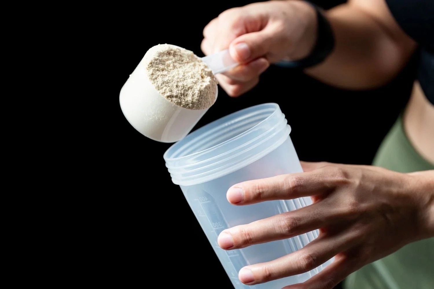 Close-up of creatine supplement scoop and shaker cup