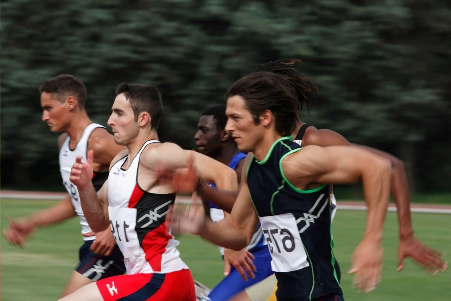 Male athletes sprinting in a competitive race, illustrating high-intensity performance.