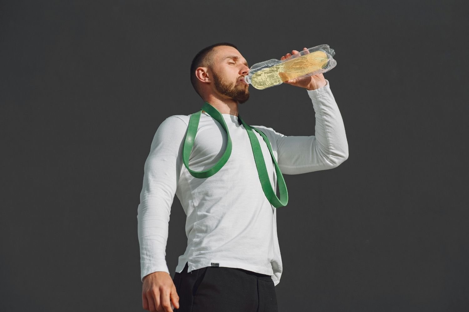 Man drinking from a bottle after a workout to support hydration and recovery