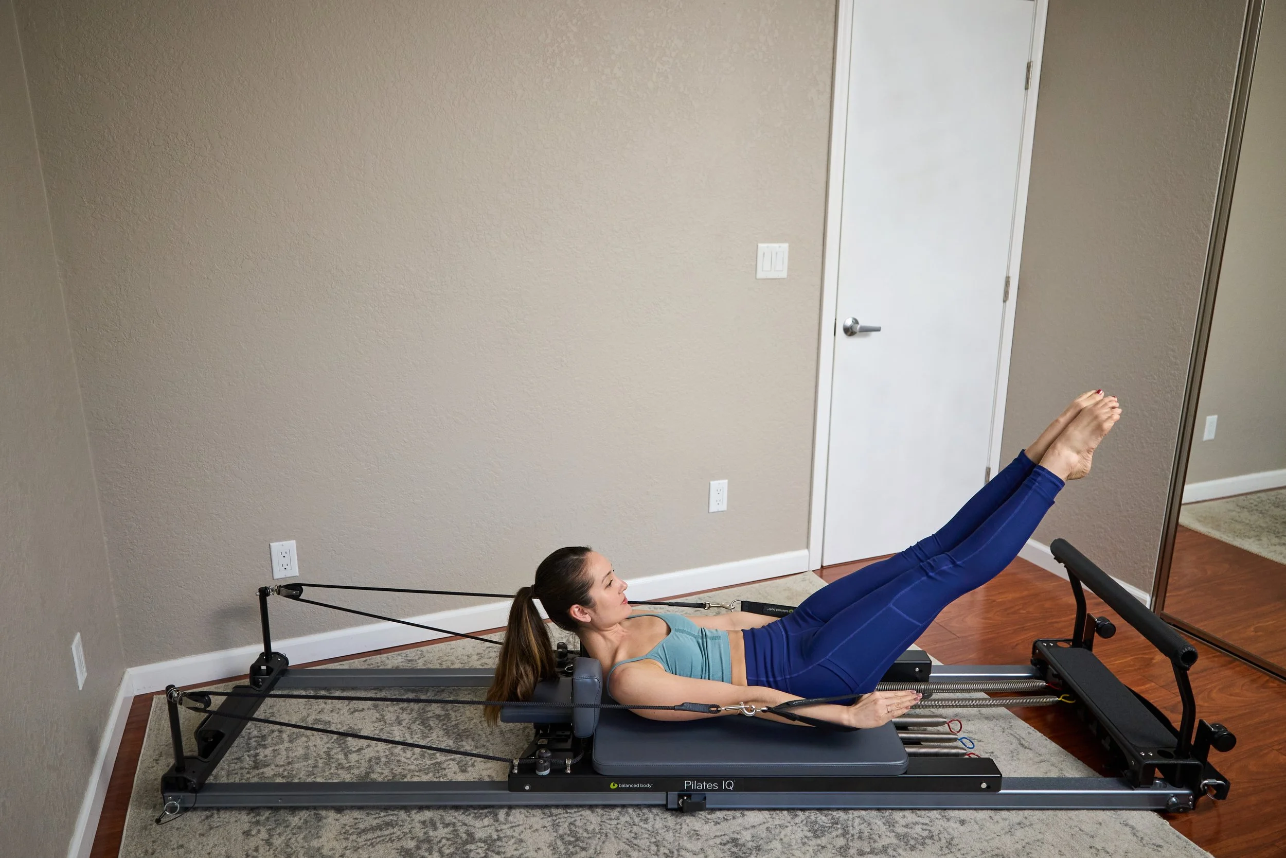 Pilates instructor performing the hundreds abdominal exercise on the Balanced Body Pilates Reformer machine
