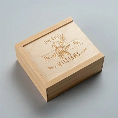 A wooden box with a lid engraved with a floral design and the words 'Love Bros', 'Mr. & Mrs.', and 'Williams'.