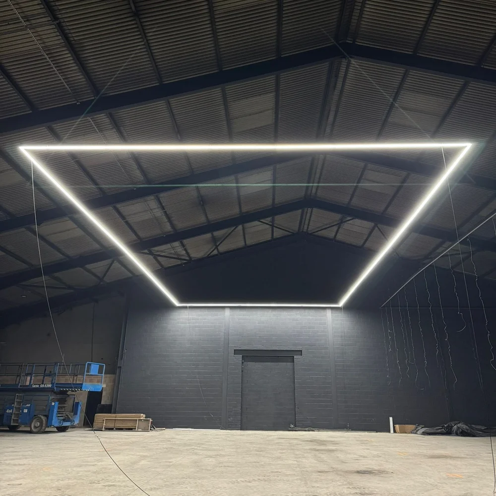 The empty Nexo Padel Club unit in Blackburn during the build, lit by a rectangle of ceiling light