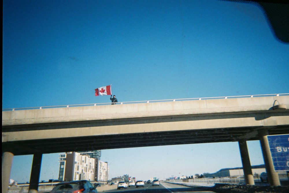  Ontario 2022 - A Canadian waves a Canadian flag over the QEW while the trucker protests happened in Ottawa. 