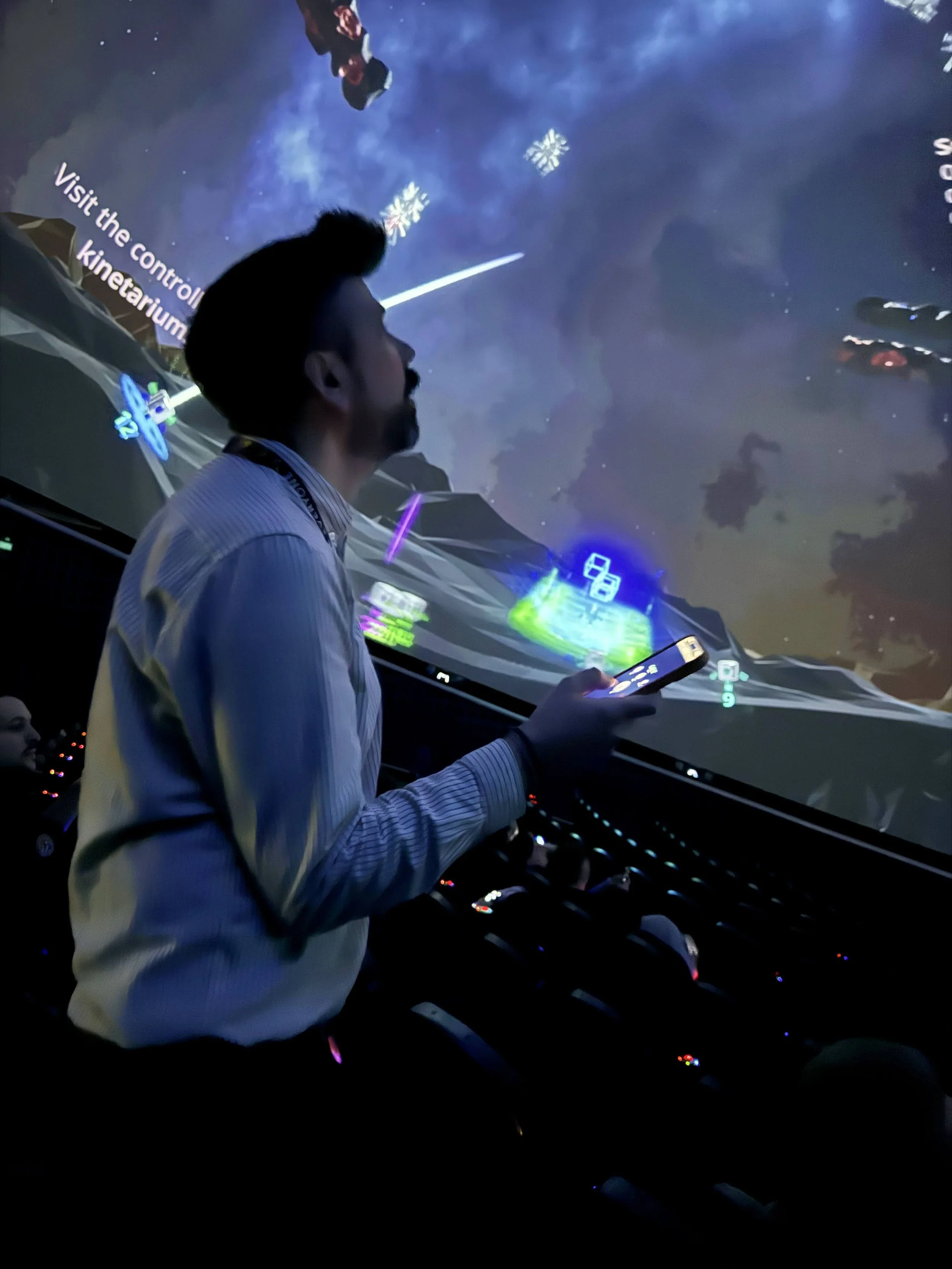 Besucher spielt mit seinem Smartphone als Controller das Kinetarium Game Dome Defenders