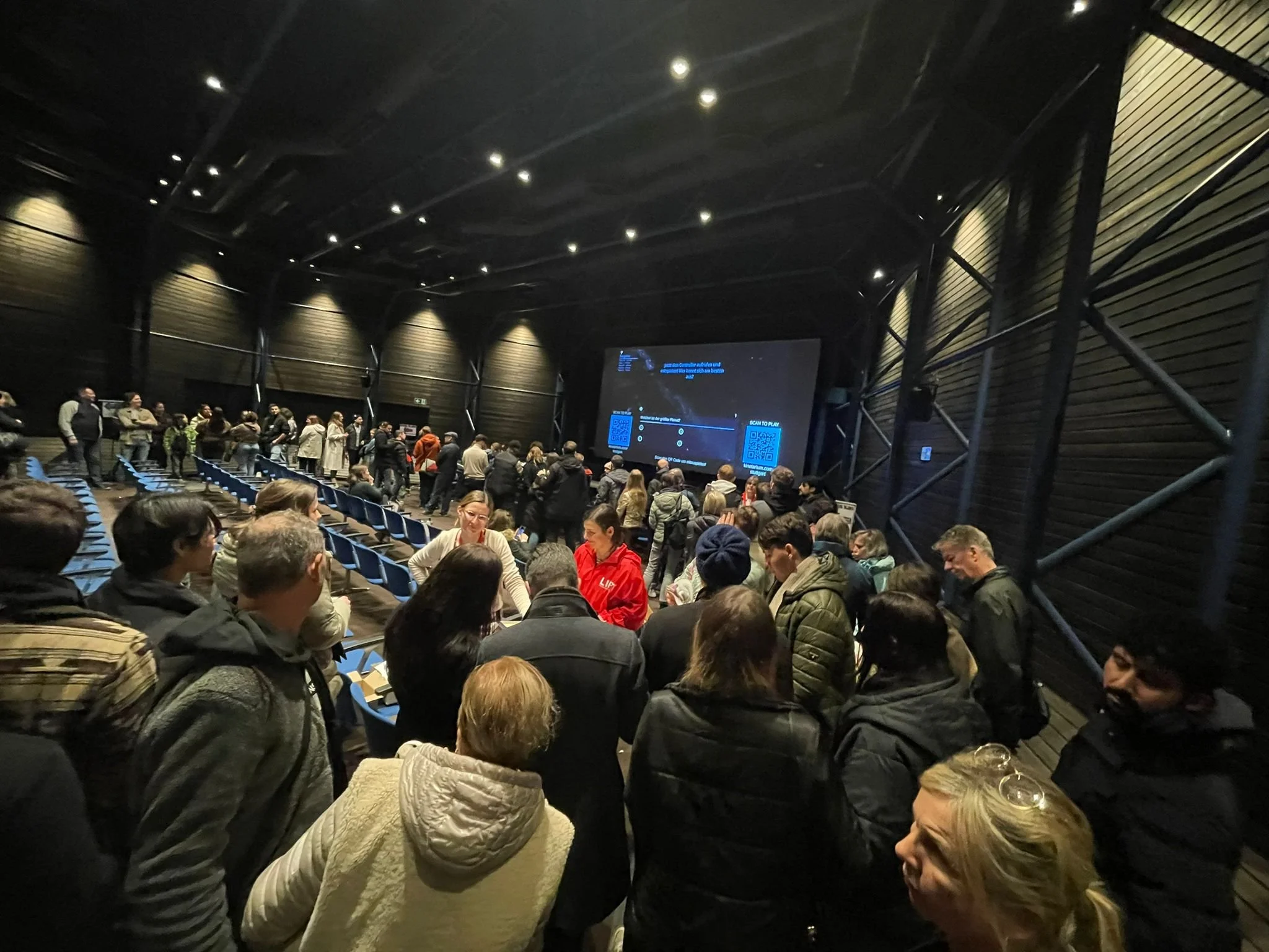 Besucher des Planetarium Stuttgarts vertreiben sich die Wartezeit indem Sie Quizgalaxy auf einem großen Bildschirm spielen