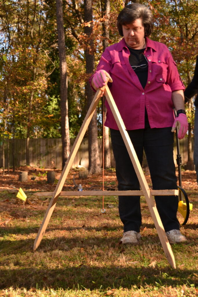 A student using a homemade A-frame level to mark a contour line Photo credit Lauren Ladov