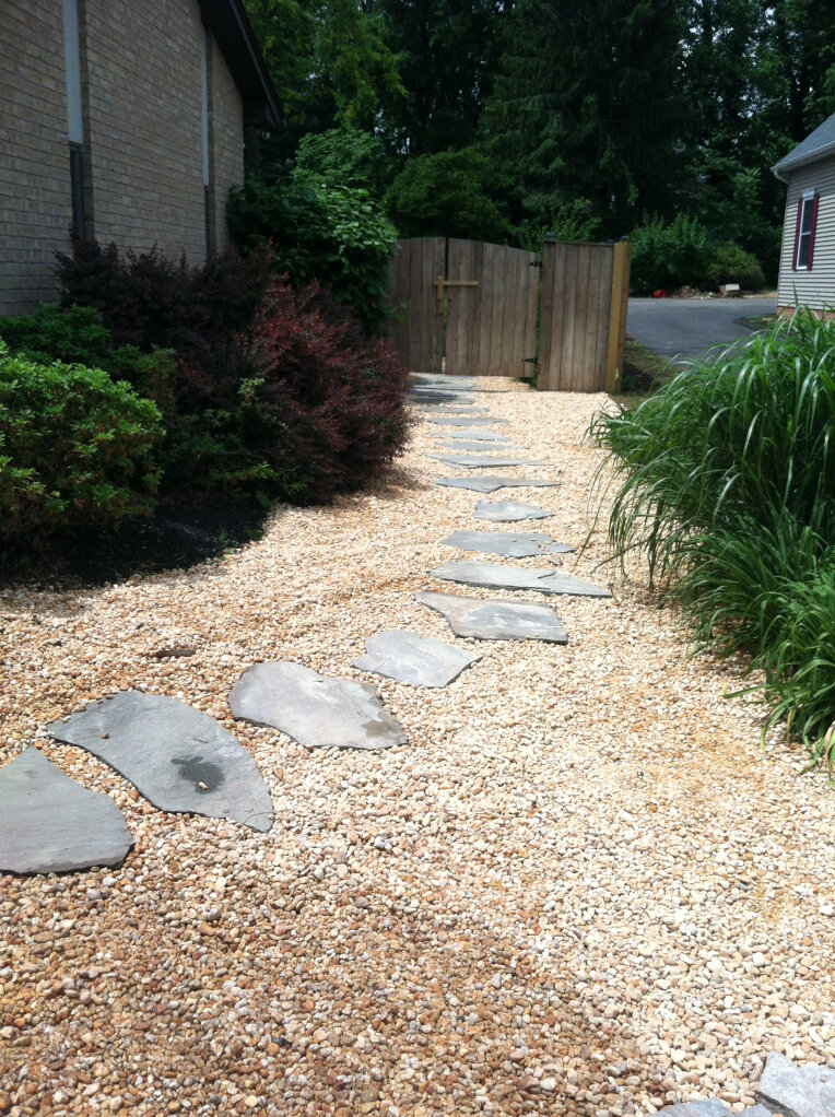 Flagstone pathway sits atop a French drain that pulls water away from the house foundation