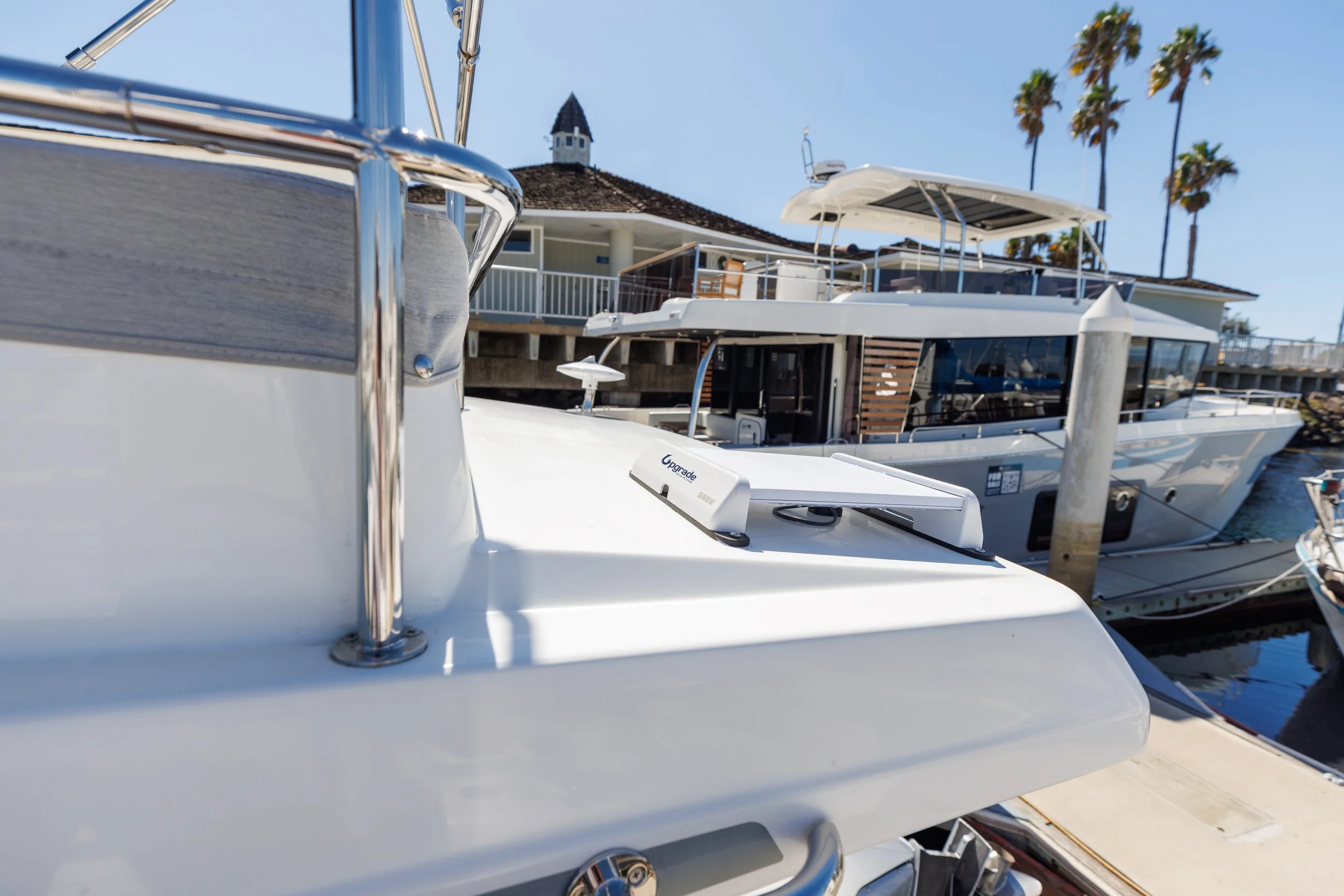 Starlink Mini satellite internet antenna flat-mounted along the aft edge of a Beneteau Antares 11 flybridge.