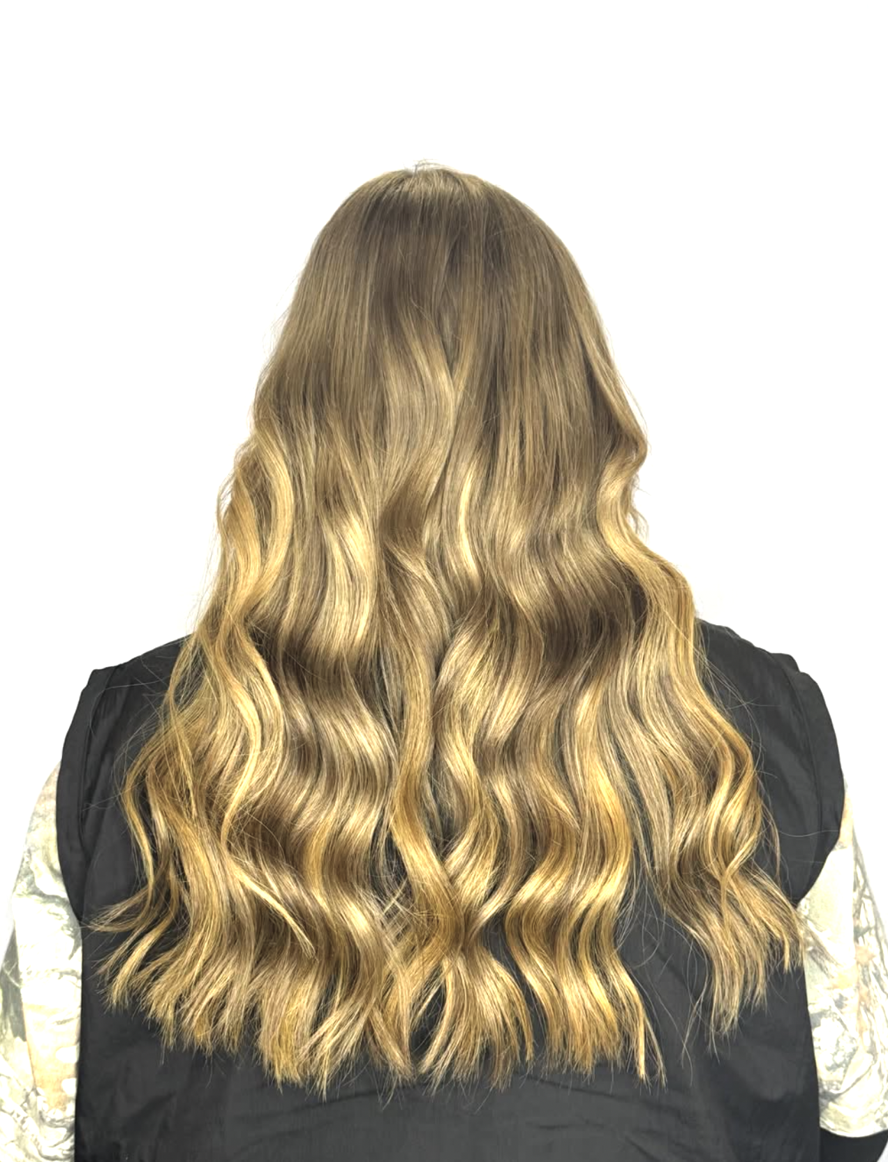 Back view of a woman with long, wavy, blonde hair.