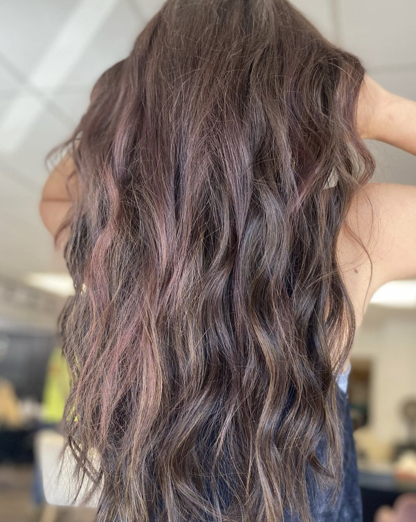 Close-up of wavy, multi-toned hair with shades of purple, pink, and brown.