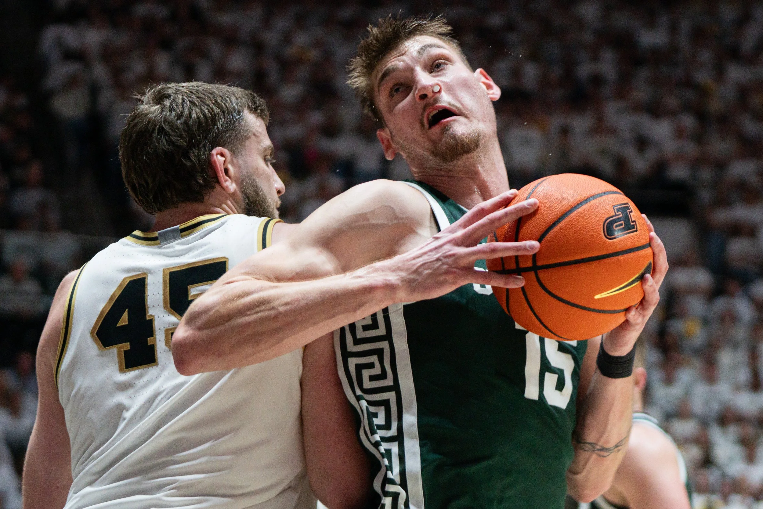 Michigan State Spartans center Carson Cooper (15) dribbles around Purdue Boilermakers center Oscar Cluff (45) during the first half at Mackey Arena. 