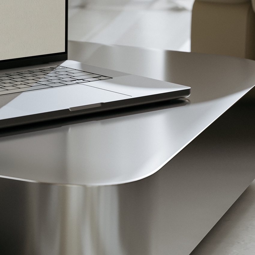 Sleek laptop on a polished metal table with a reflective surface in a modern setting.