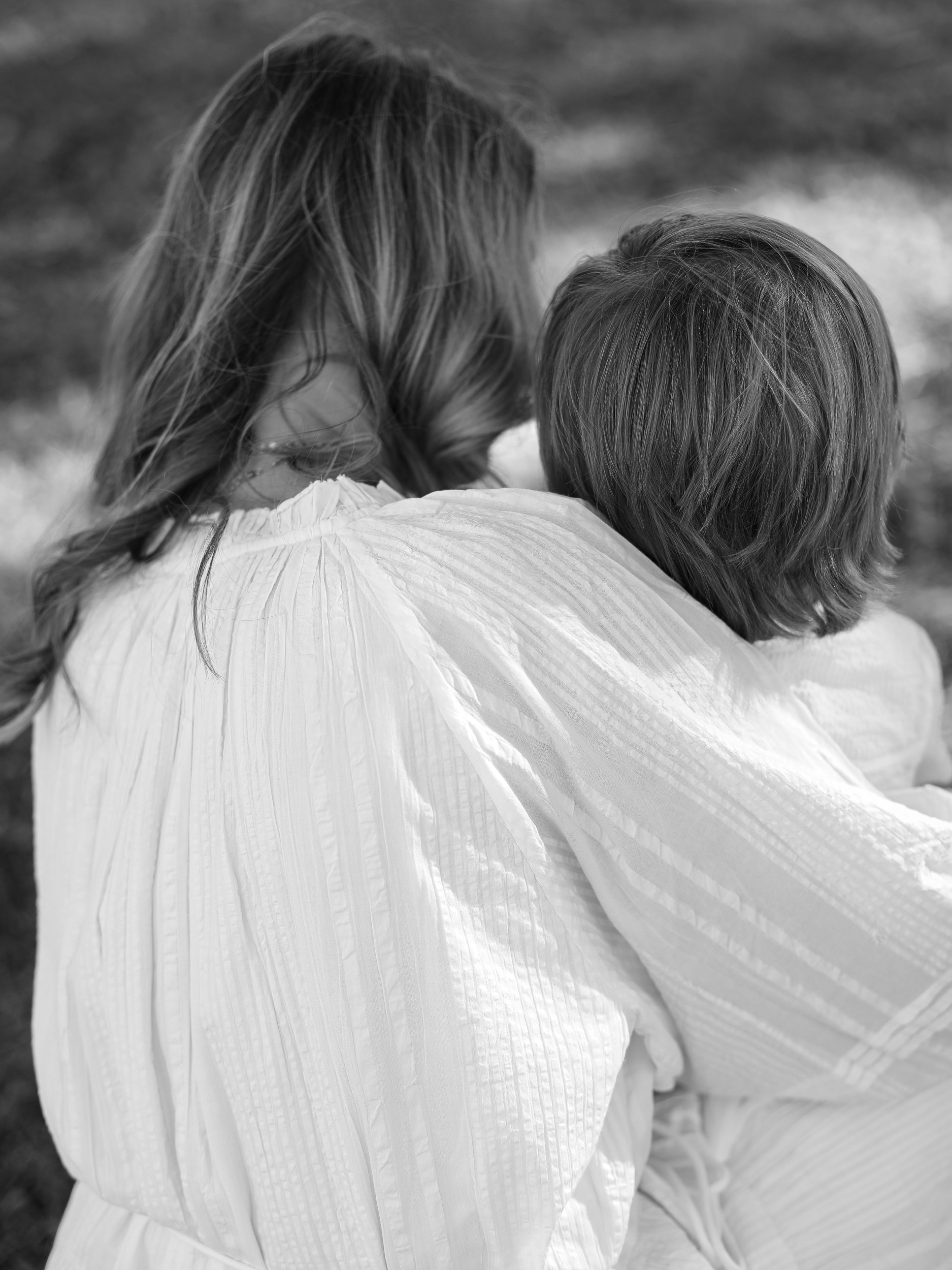 A woman with wavy hair is holding a child in her arms.