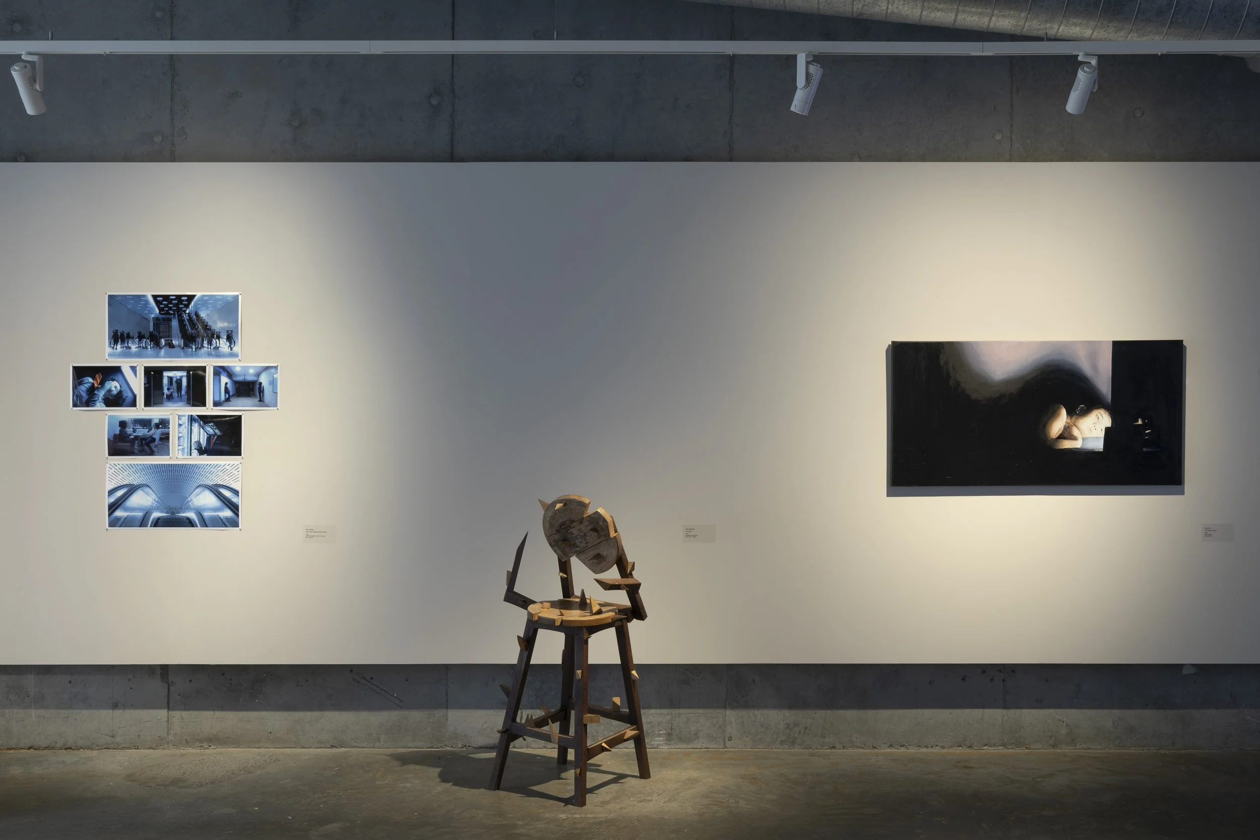 Left to right. Futuristic photo series in blue monotone. Fragmented wooden chair statue with spikes.  Painting of person lying in bed, surrounded by darkness, only illuminated by the light from their screen.