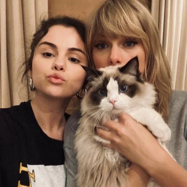 Taylor Swift and Selena Gomez taking a selfie while Taylor holds her seal bicolor Ragdoll cat Benjamin Button