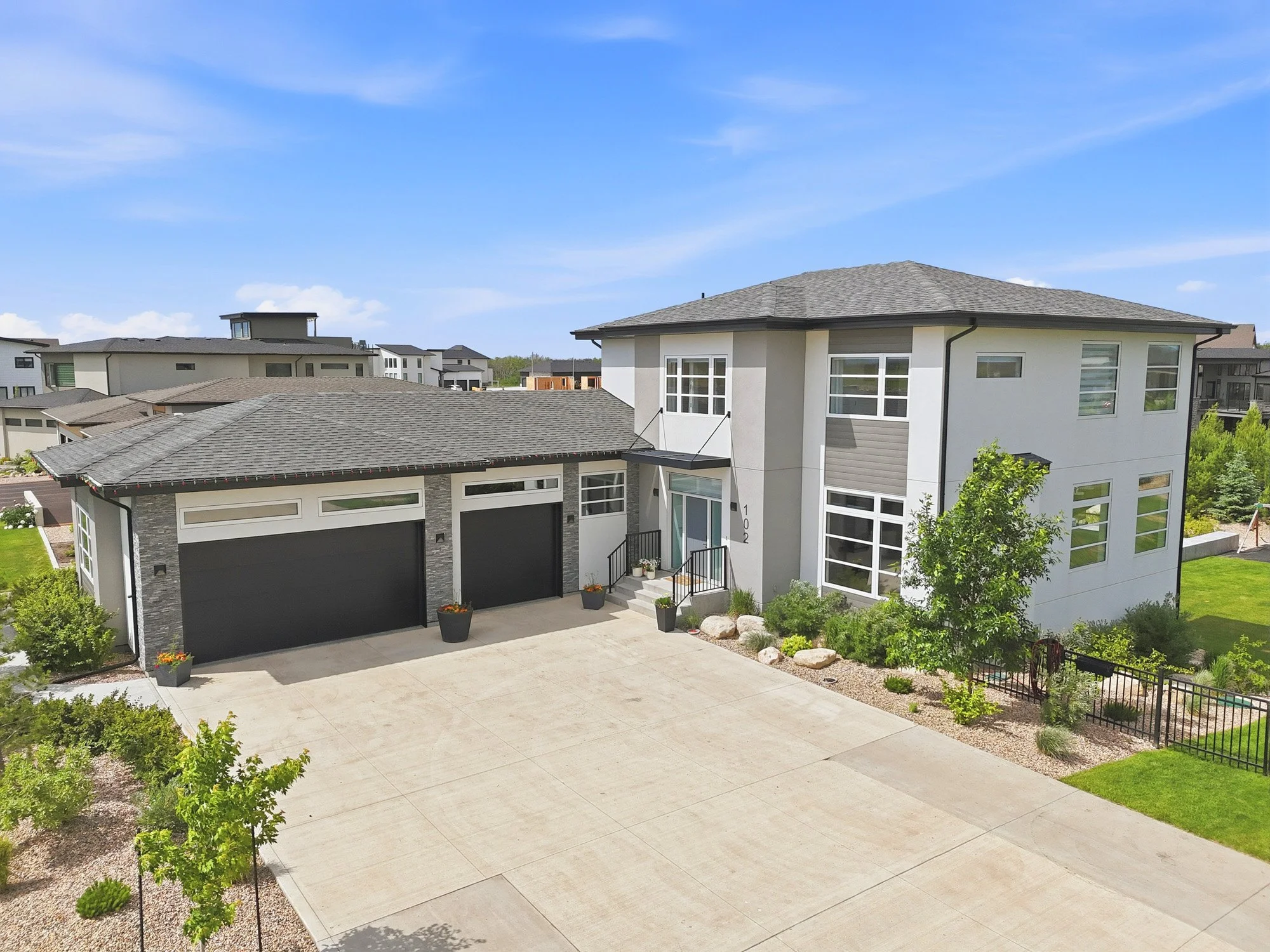 Aerial front view of a contemporary Saskatoon home with multiple garages and modern architectural details