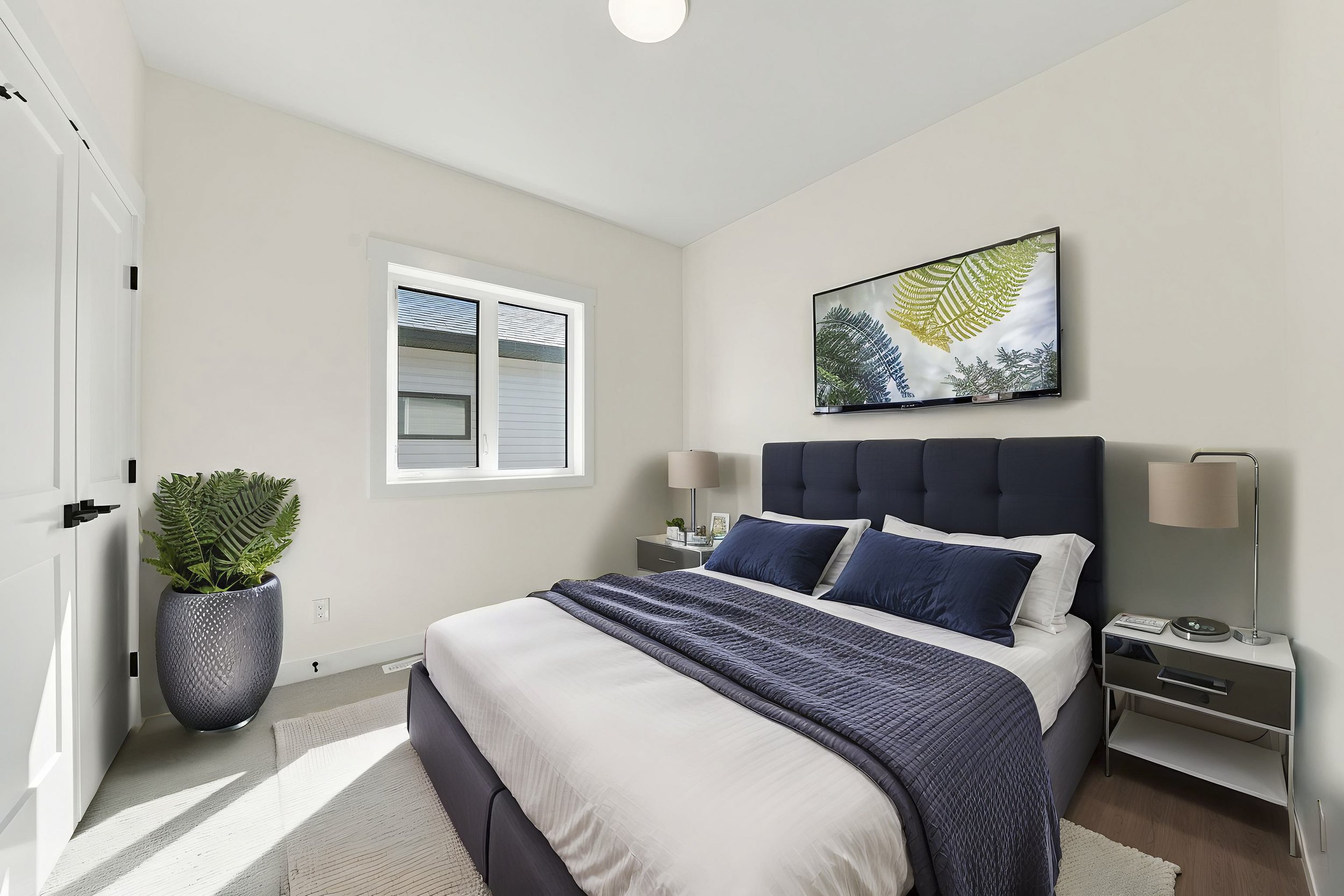 Virtually staged secondary bedroom with modern bed, artwork and navy accents