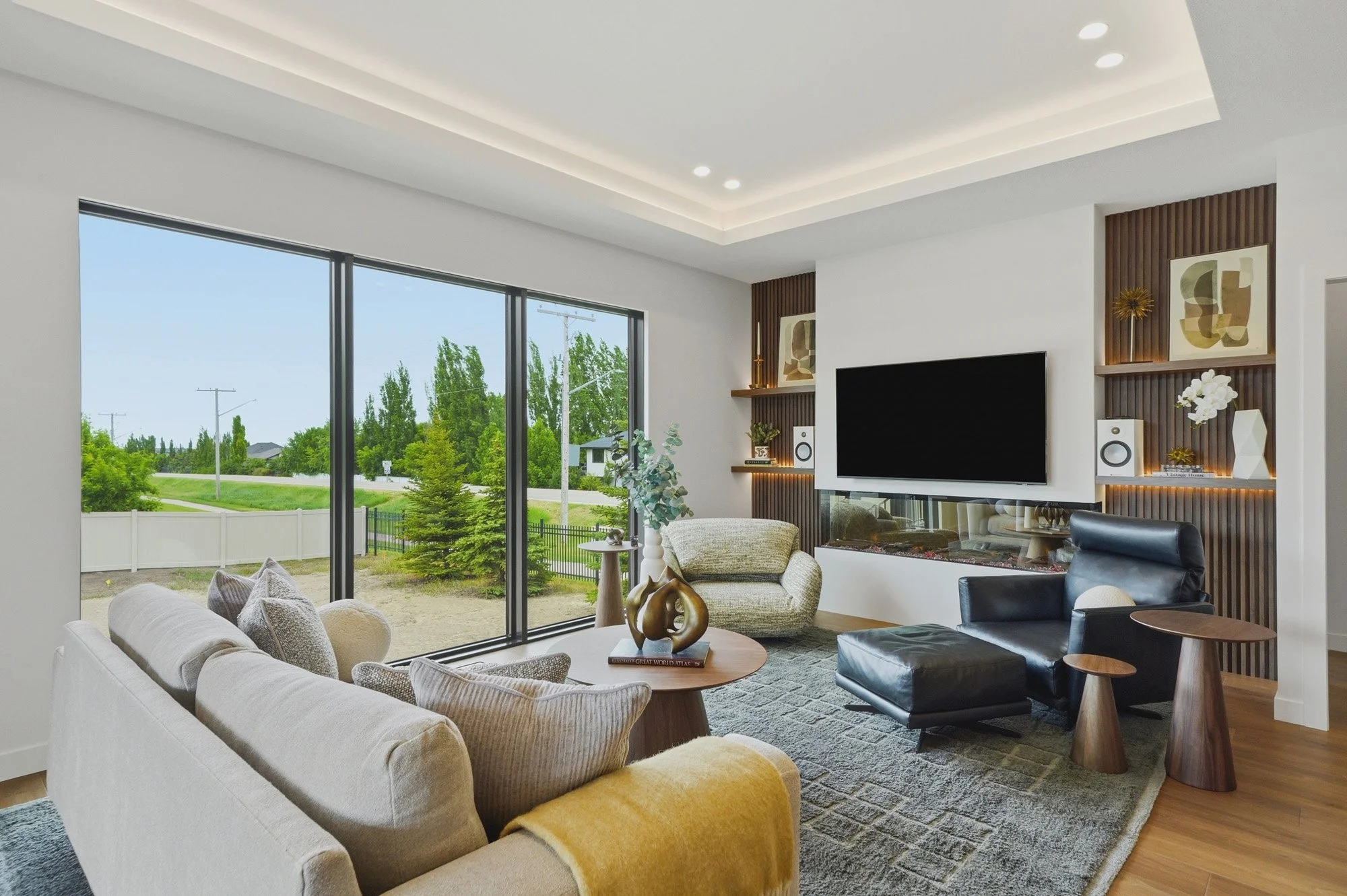 Bright modern living room with floor-to-ceiling windows, custom wood shelving and a linear fireplace.