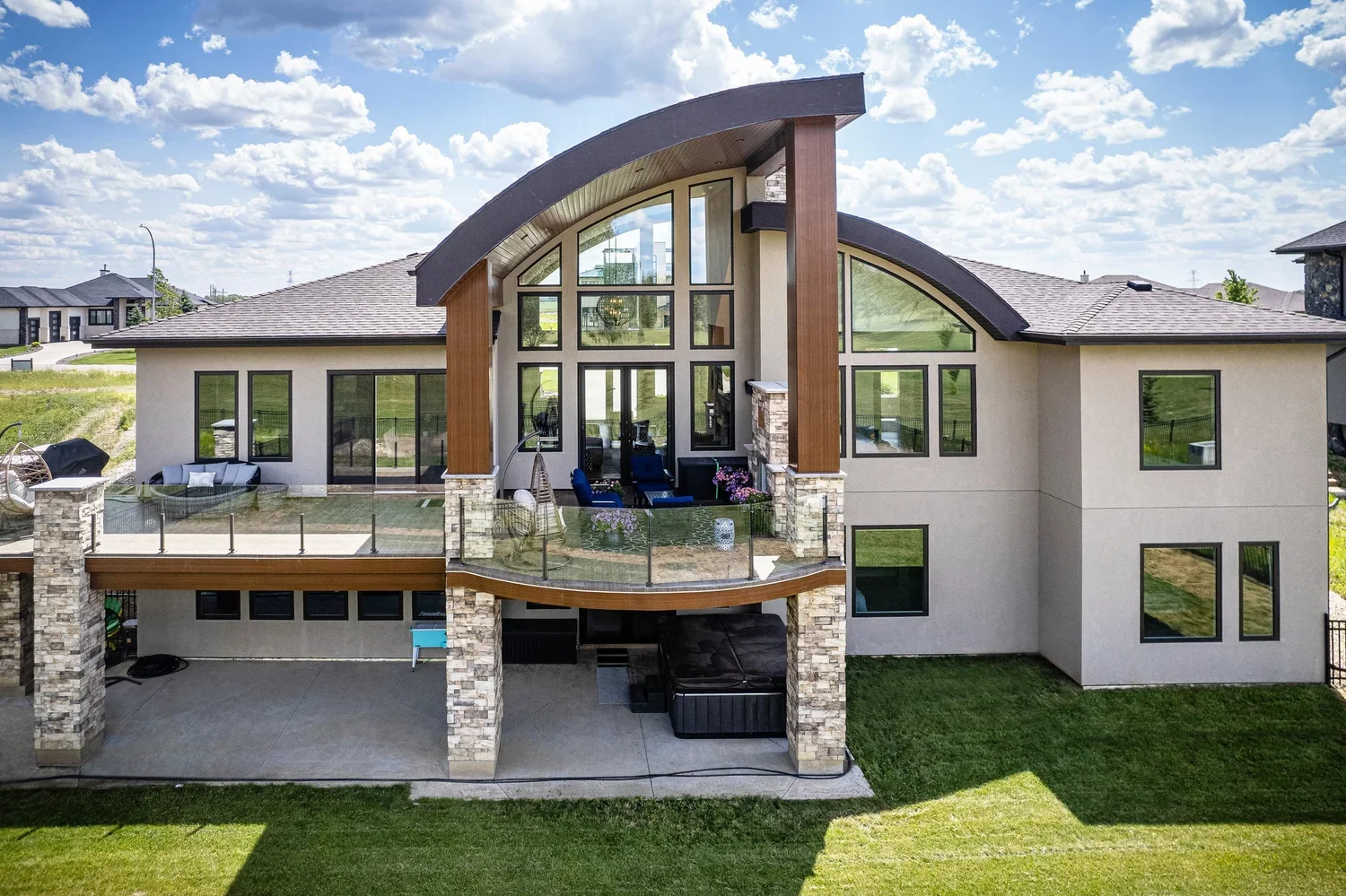 Aerial view of a luxury home's rear exterior, pool and landscaped backyard.