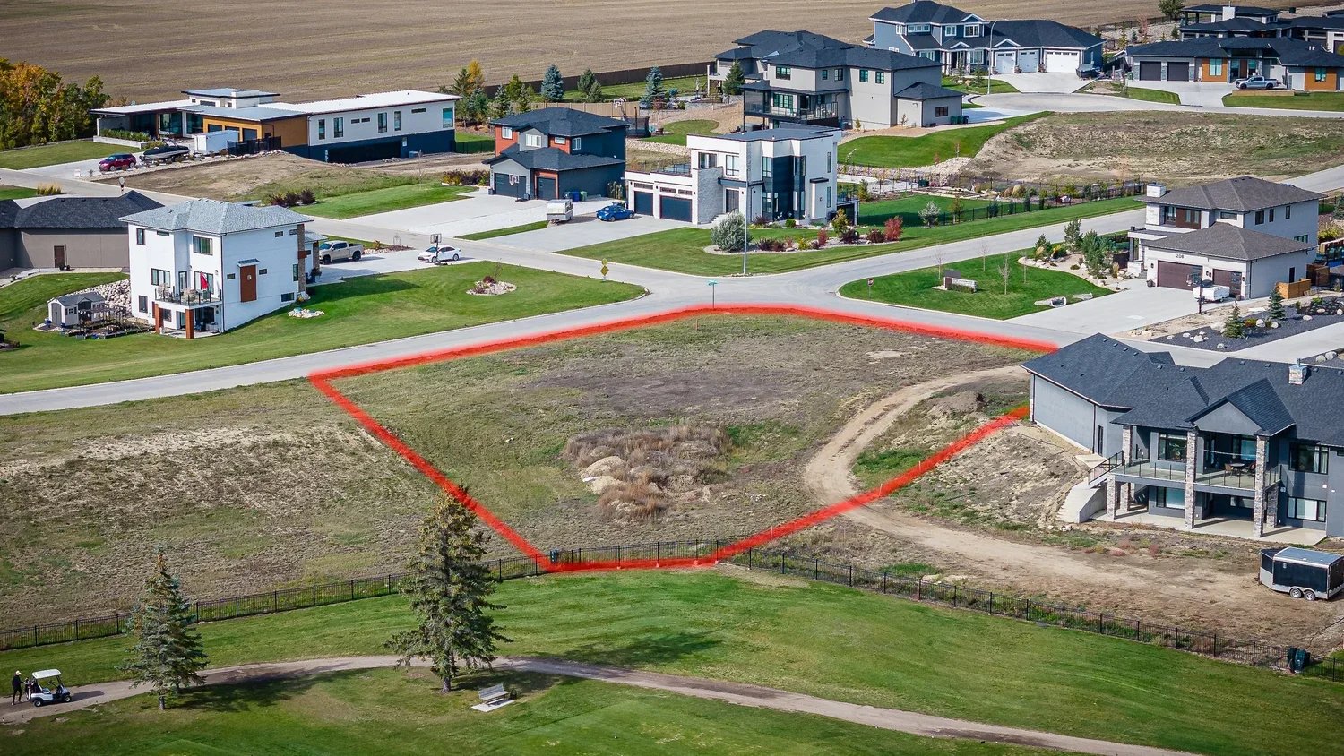 Aerial view of an empty residential lot outlined in red for sale in Greenbryre, Saskatoon.