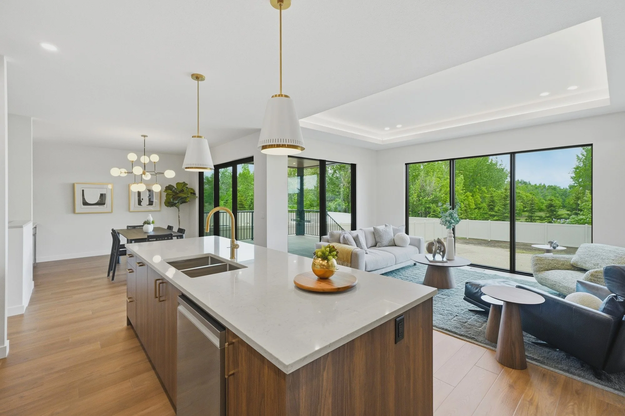 Modern open-concept kitchen and living room with large windows, pendant lights, and real estate photography Saskatoon views.