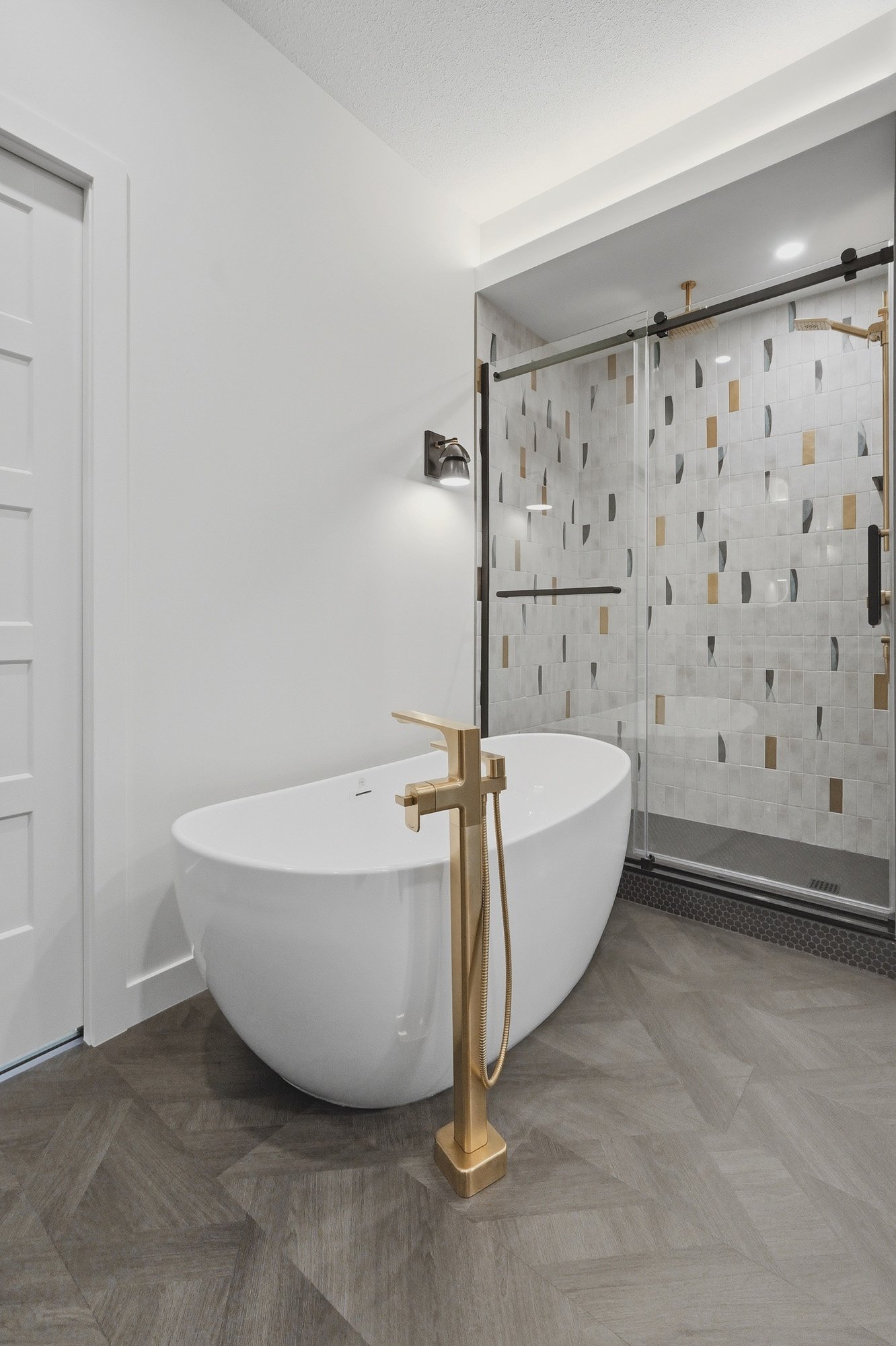 Modern bathroom with a white freestanding tub, gold faucet, and glass shower—perfect for real estate photography Saskatoon style.