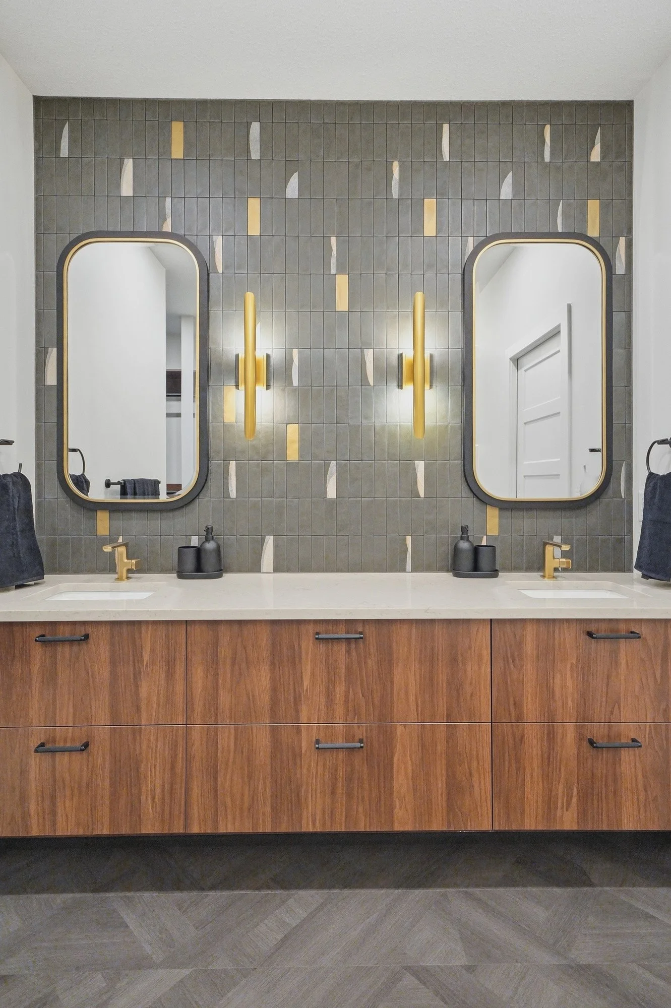 Modern bathroom with wood vanity, gold fixtures, dual mirrors, and geometric tile—ideal for real estate photography Saskatoon.